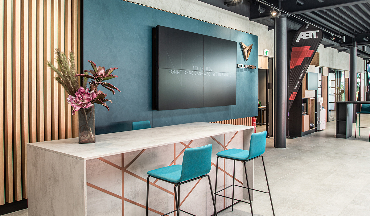 Wanddetail im Innenbereich der CUPRA Garage Hamburg mit beleuchtetem CUPRA Logo